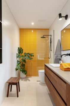 a modern bathroom with yellow tiles on the walls