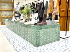 an assortment of shoes and clothing on display in a store