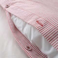 a close up view of a red and white striped bed spread with buttons on it