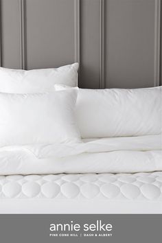 an image of a bed with white sheets and pillows