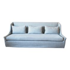 a light blue couch with four pillows on it's back and three sides, in front of a white background