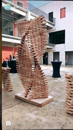 a sculpture made out of wooden planks in front of a building