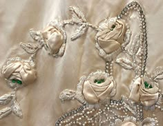 an embroidered fabric with flowers and pearls on it