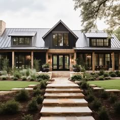 a large house with lots of windows and steps leading up to the front door area