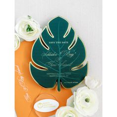 an orange and green wedding card with white flowers