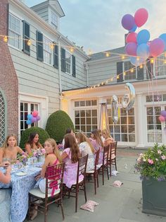 a group of people sitting around a table with balloons