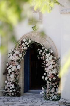 an archway decorated with flowers and greenery