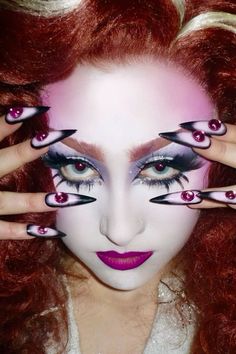 a woman with red hair and makeup holding her hands up to her face as if she is looking at the camera