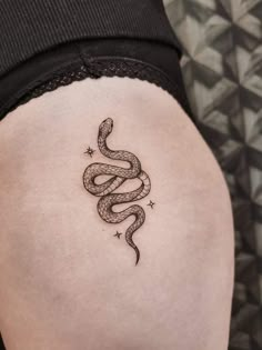 a woman's thigh with a snake tattoo on it