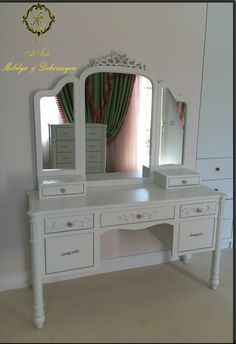 a white dressing table with drawers and a mirror