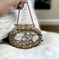 Introducing our mother of Pearl Clutch- a true masterpiece of elegance. This oval shaped clutch features a luxurious 14k gold frame, complemented by meticulous peals and Crystal embellishments. The inner lining, crafted with plush suede fabric, enhances the tactile experience, making it as delightful to touch as it is to behold. The meticulous attention to detail extends to the heavy premium quality chain, ensuring a seamless blend of style and practicality. With dimensions of 7X5 inches, this c Luxury Gold Clutch With Gold-tone Hardware, Handmade Glamorous Evening Bag For Wedding, Luxury Evening Bag With Gold-tone Hardware For Gift, Elegant Gold Clutch For Wedding, Elegant Jewelry With Gold-tone Hardware For Formal Occasions, Elegant Formal Jewelry With Gold-tone Hardware, Gold Clutch With Gold-tone Hardware For Formal Events, Gold Clutch With Gold-tone Hardware For Formal Occasions, Formal Gold Clutch With Gold-tone Hardware