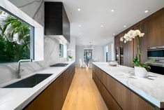 a large kitchen with marble counter tops and wooden cabinets, along with an island in the middle