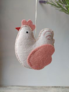 a white and pink bird ornament hanging from a tree