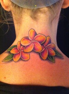 a woman's neck with a flower tattoo on the back of her neck,