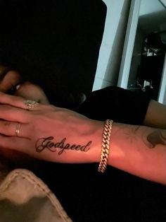 a person with a tattoo on their arm and hand that says, godgaed