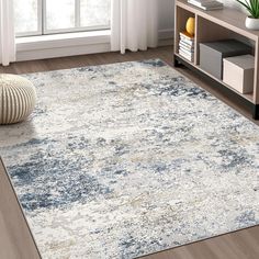 an area rug in a living room with wooden flooring