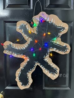 a door hanger decorated with christmas lights and an image of a cat on it