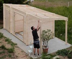 a man standing next to a wooden structure