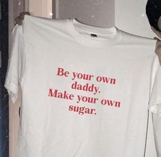 a man holding up a t - shirt that says be your own daddy make your own sugar