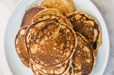 a white plate topped with pancakes on top of a table