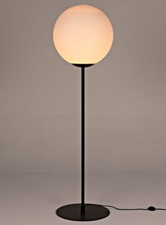 a lamp that is on top of a black base with a white ball light in the middle