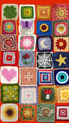 crocheted squares are arranged in rows on a red tablecloth with flowers and hearts