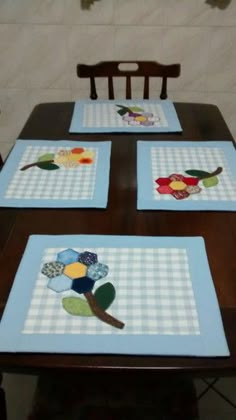 four placemats with flowers on them sitting on a table