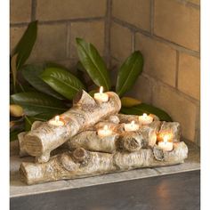 a group of logs with lit candles in them