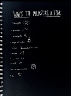 a spiral notebook with writing on it that says ways to measure a year written in white chalk