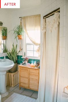 a bathroom with a sink, mirror and plants in the window sill next to it