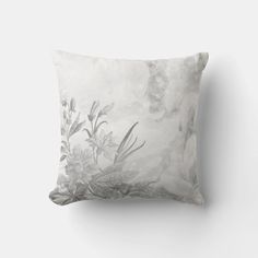 a white and grey pillow with flowers on it