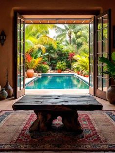 an open door leading to a pool in the middle of a room with a rug on the floor