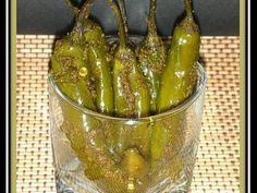 a glass bowl filled with green chili peppers