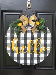 a black and white checkered door hanger with the word hello on it