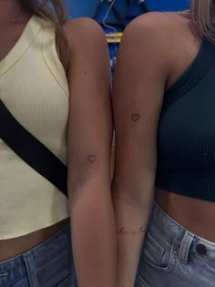 two women with small tattoos on their arms