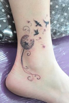 a woman's foot with a dandelion tattoo on the side of her leg