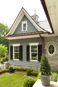 a gray house with white windows and brown shutters