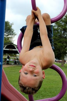 a young boy is playing on a purple ring