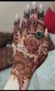 a woman's hand with henna and ring on it