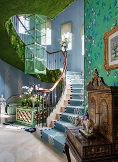 a staircase in a house with blue walls and floral wallpaper on the walls, along with green carpeted stairs