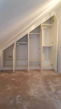 an attic bedroom with white closets and carpeted flooring on the bottom level