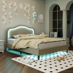 a bedroom with a bed, night stand and rugs on the wooden flooring