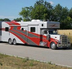 an rv is parked on the side of the road in front of some tall grass