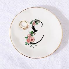 a white plate with a smiley face painted on it and two gold rings in the middle