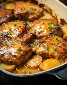 some meat and potatoes in a pan with gravy on the top is ready to be eaten