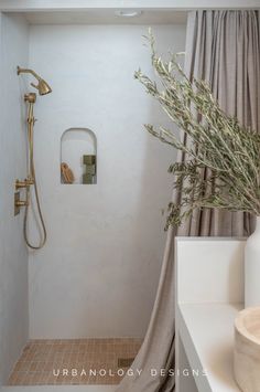 a bathroom with a shower, toilet and sink in it's corner area next to a window