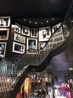 a staircase with pictures on the wall and glass balconies in front of it