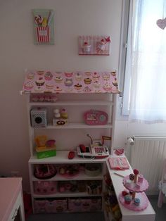 a doll house with pink furniture and accessories in the room, including a toy kitchen