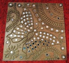 a decorative metal plate with holes in it