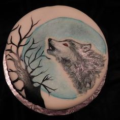 a cake decorated with an image of a wolf and tree